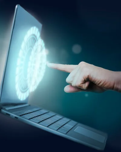 Mano señalando un panel holográfico sobre la pantalla de una computadora portátil, simbolizando tecnología web avanzada