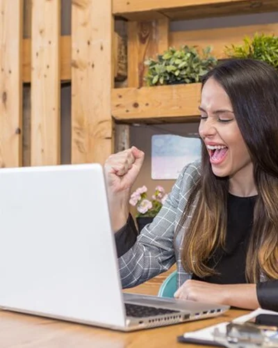 Mujer sonriente celebrando el éxito al mejorar el posicionamiento SEO de su empresa con SkipperLab